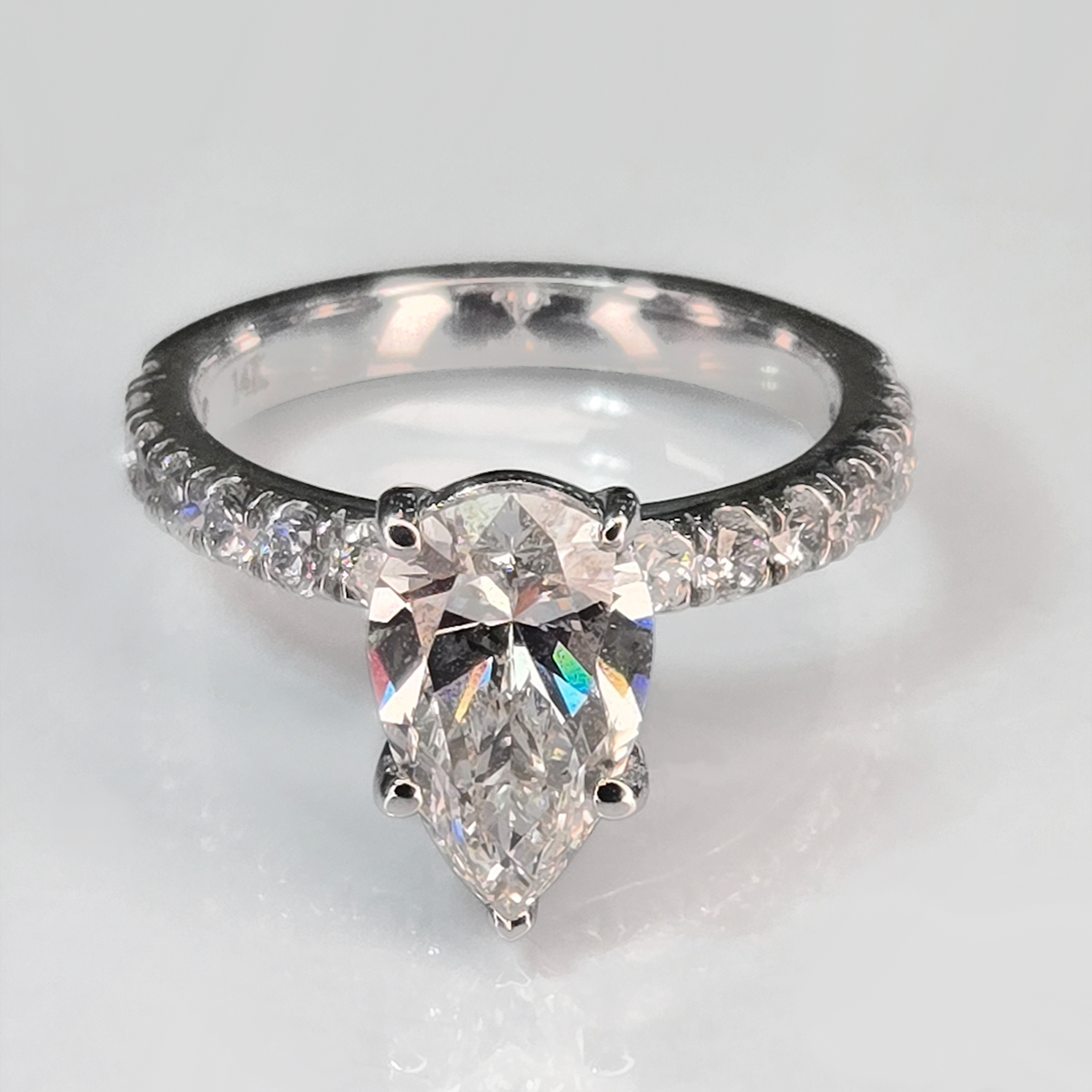 The 2.09 ct center stone creates a bold focal point, while seven round accent diamonds in the band add subtle sparkle that enhances the ring without overwhelming its clean, solitaire-inspired design.