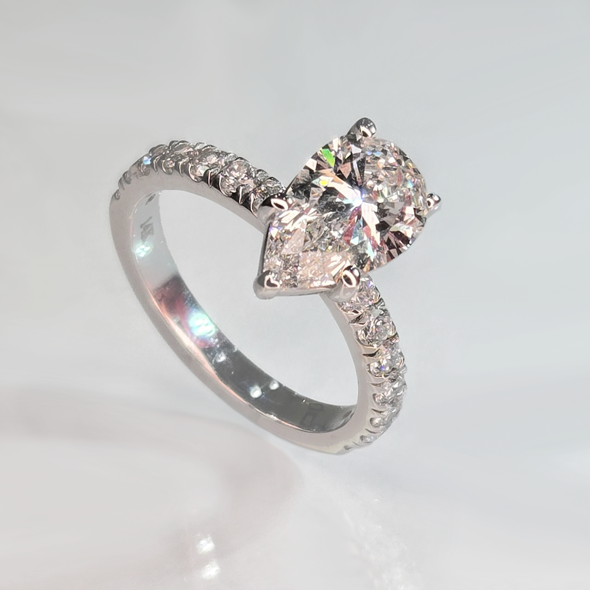 The 2.09 ct center stone creates a bold focal point, while seven round accent diamonds in the band add subtle sparkle that enhances the ring without overwhelming its clean, solitaire-inspired design.