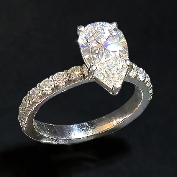 The 2.09 ct center stone creates a bold focal point, while seven round accent diamonds in the band add subtle sparkle that enhances the ring without overwhelming its clean, solitaire-inspired design.