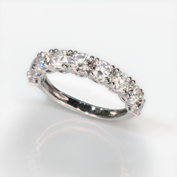 A bold, balanced design featuring a brilliant center diamond complemented by a band of round diamonds that enhance its overall presence.