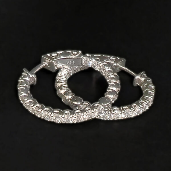 A classic hoop earring set with dazzling round cut diamonds against white gold.